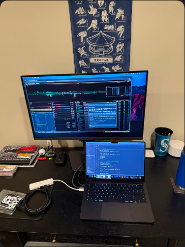 workbench with laptop, monitor, hardware, and terminal sessions